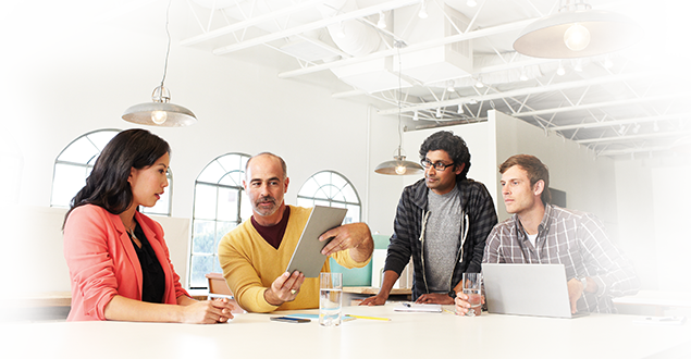 business people sitting and talking while looking at a tablet